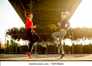 Young Woman Exercising With A Personal Trainer Outside In The Morning