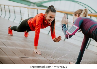 Young Woman Exercising With A Personal Trainer Outside In The Morning