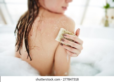 Young Woman Exfoliating Her Skin With Soap