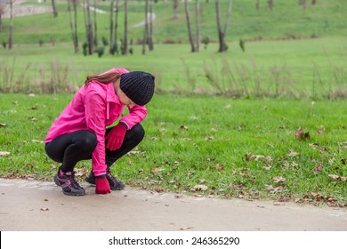 Young Woman Exhausted After Running On A Cold Winter Day In The Track Of An Urban Park.