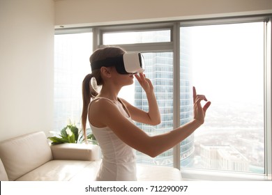 Young woman experiencing immersive virtual reality technology wearing VR glasses, interacting with 360 degrees headset user interface, choosing goods while shopping, selects content in 3d gaming menu