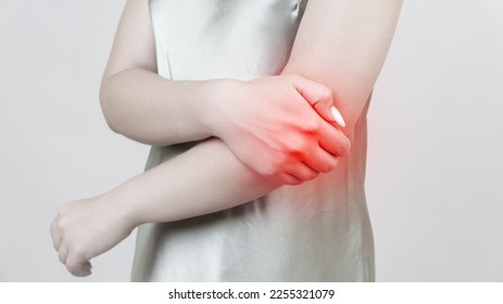 young woman experiencing pain in elbow joint - Shutterstock ID 2255321079