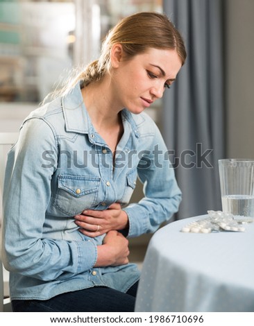 Young woman experiencing pain in the stomach. High quality photo