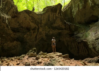 Young Woman Explorer Observing Ancient Caribbean Cave. Young Woman Explore Inside Of Cave In Tropical Rainforest. Woman Explorer Inside The Cave In Los Haitises National Park, Dominican Republic. 