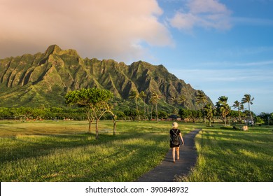 Young woman exploring Kualoa Regional Park under the Hawaiian mountains