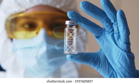 Young Woman In Eyeglasses And Face Mask With Gloves Holding Test Tube With 3d Model Of Human DNA. Health Care Concept. Infecting Process. Female Doctor Scientist Searching For Medical Innovation. 