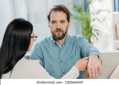 Young Woman In Eyeglasses Holding Hand Of Bearded Man During Hypnotherapy