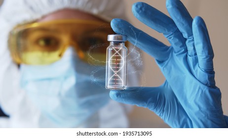 Young Woman In Eyeglasses And Protective Mask With Gloves Holding Test Tube With 3d Model Of Human DNA. Health Care Concept. Infecting Process. Female Doctor Scientist Searching For Medical Innovation