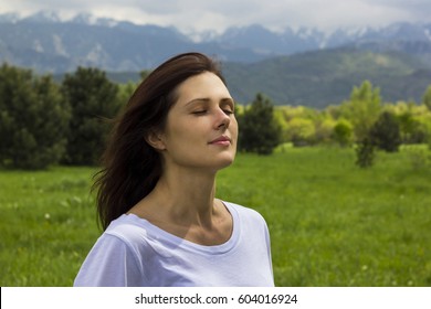 Young Woman With Eyes Closed Breathing Fresh Air In The Mountains