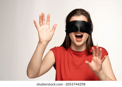 Young woman with eyes tied and arms up, isolated on white.
