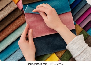 Young Woman With Fabric Samples For Curtains At Table. Multiple Color Fabric Texture Samples Selection Fabrics For Interior Decoration. Furniture Upholstery