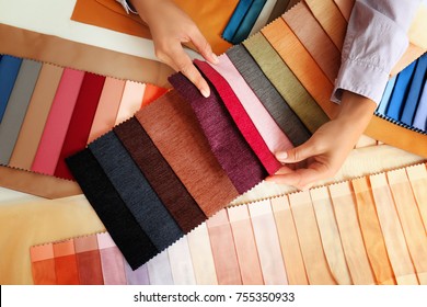 Young woman with fabric samples for curtains at table - Powered by Shutterstock