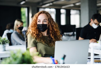 Young Woman With Face Mask Back At Work In Office After Lockdown.