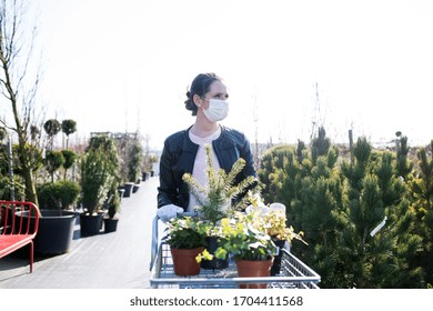 Young Woman With Face Mask Outdoors Shopping In Garden Center, Corona Virus Concept.