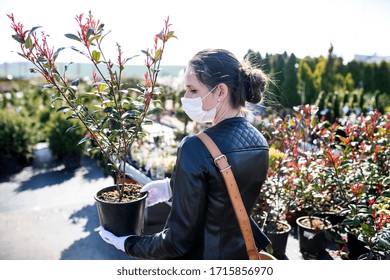 Young Woman With Face Mask Outdoors Shopping In Garden Center, Corona Virus Concept.