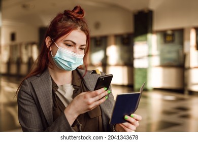 Young Woman In Face Mask Taking Photo Her Passport On Cellphone At Train Station Indoors