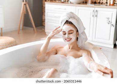 Young Woman With Facial Mask Taking Relaxing Bath At Home