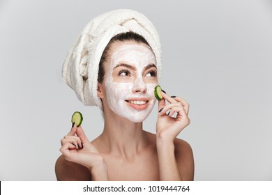 Young Woman With Facial Skincare Mask And Cucumber Slices Isolated On White