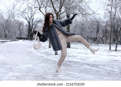 Young woman falling on slippery icy pavement in park
