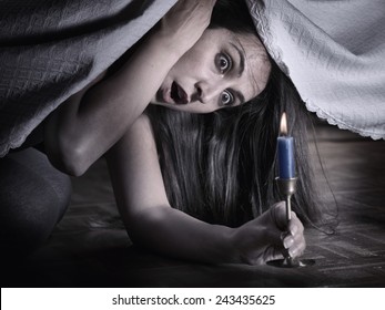 A Young Woman With Fear, Looking Under The Bed And Surprised At What She Sees