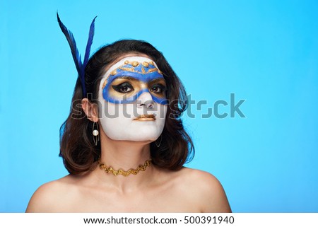 young woman with feather in hair on blue background