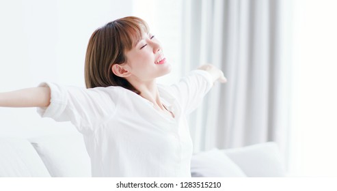 Young Woman Feel Carefree And Stretch Arm To Take A Deep Breath At Home