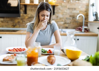 Young Woman Feeling Nausea During Breakfast Time At Dining Table 