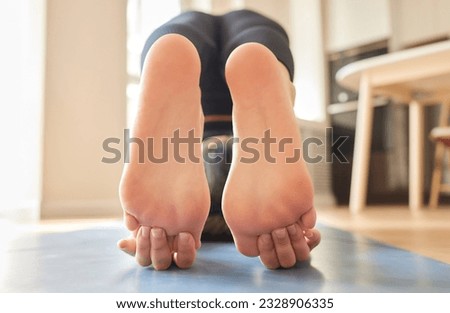 Young woman feeling pain in her foot while exercise at home