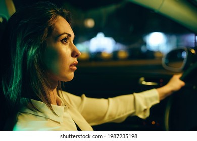 Young Woman Feeling Sad And Crying While Driving Car Alone At Night.