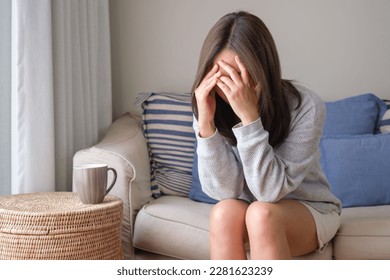 A young woman feeling sad and stressed, sick and headache at home