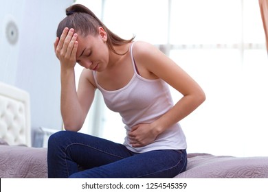 Young woman feels bad and experiences abdominal pain during the period of PMS and menstruation. Painful menstruation. Inflammation and Bladder Infection. Copy space 