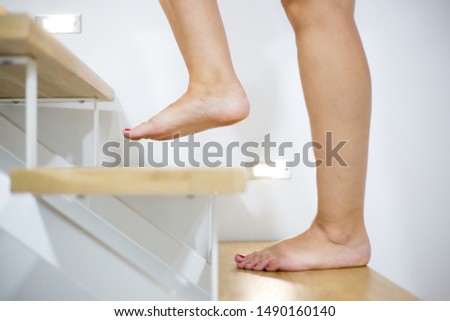 Young woman feets on the wood stairs