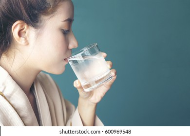 Young woman felling thirsty, drinking cold water after finished from hot sauna session at Spa Center - Spa Concept