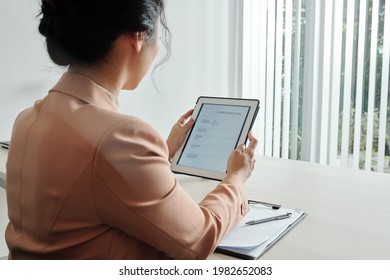 Young Woman Filling Cv Form On Tablet Computer, View From The Back