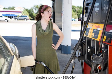 Young Woman Filling Up Her Gas Tank Is Shocked By The High Fuel Prices.