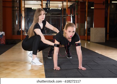 Young Woman Fitness Instructor Works With Woman Wearing Ems Equipment As She Exercises In A Studio
