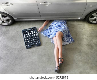 Young Woman Fixing A Car In A Garage.