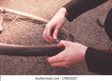 Young woman is fixing her bike and pumping her tires - Powered by Shutterstock