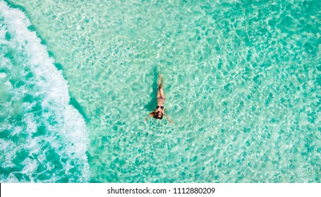 Young woman floating in the clear sea of the Mexican Caribbean. Cancun, Mexico. - Powered by Shutterstock