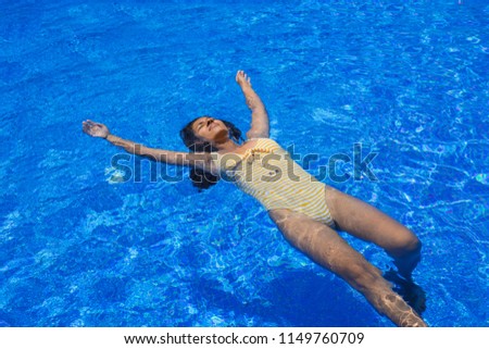 young woman floating in the pool