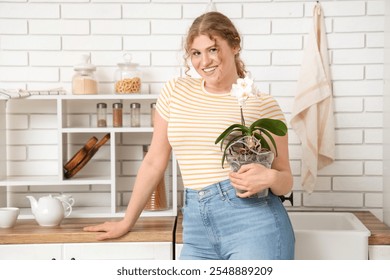 Young woman with flower in kitchen - Powered by Shutterstock