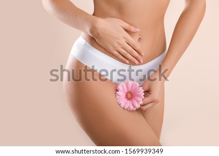 Young woman with flower on light background. Gynecology concept