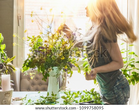 Similar – Woman makes wildflower bouquet in vase on the table