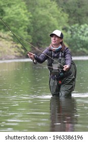 Young Woman Fly Fishing For Trout In A Clear River