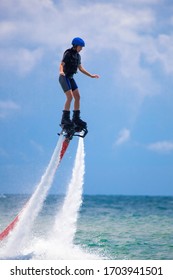 Young Woman Is Flying At The Aquatic Flyboard. Water Extreme Spo