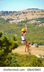 Young Woman Flying Down On Zipline In Mountain, Extreme Sport