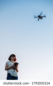 Young Woman Flying Drone In The Park. Copy Space