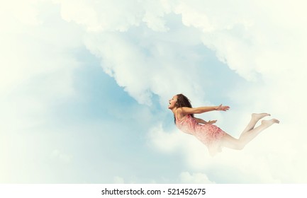 Young Woman Flying High In Blue Sky