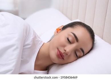 Young Woman With Foam Ear Plugs Sleeping In Bed