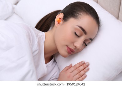 Young Woman With Foam Ear Plugs Sleeping In Bed